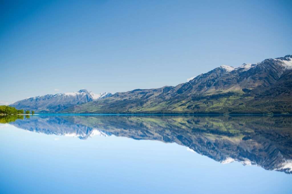 Fine‑art landscape photograph featuring a glassy alpine lake and symmetrical mountain reflections.