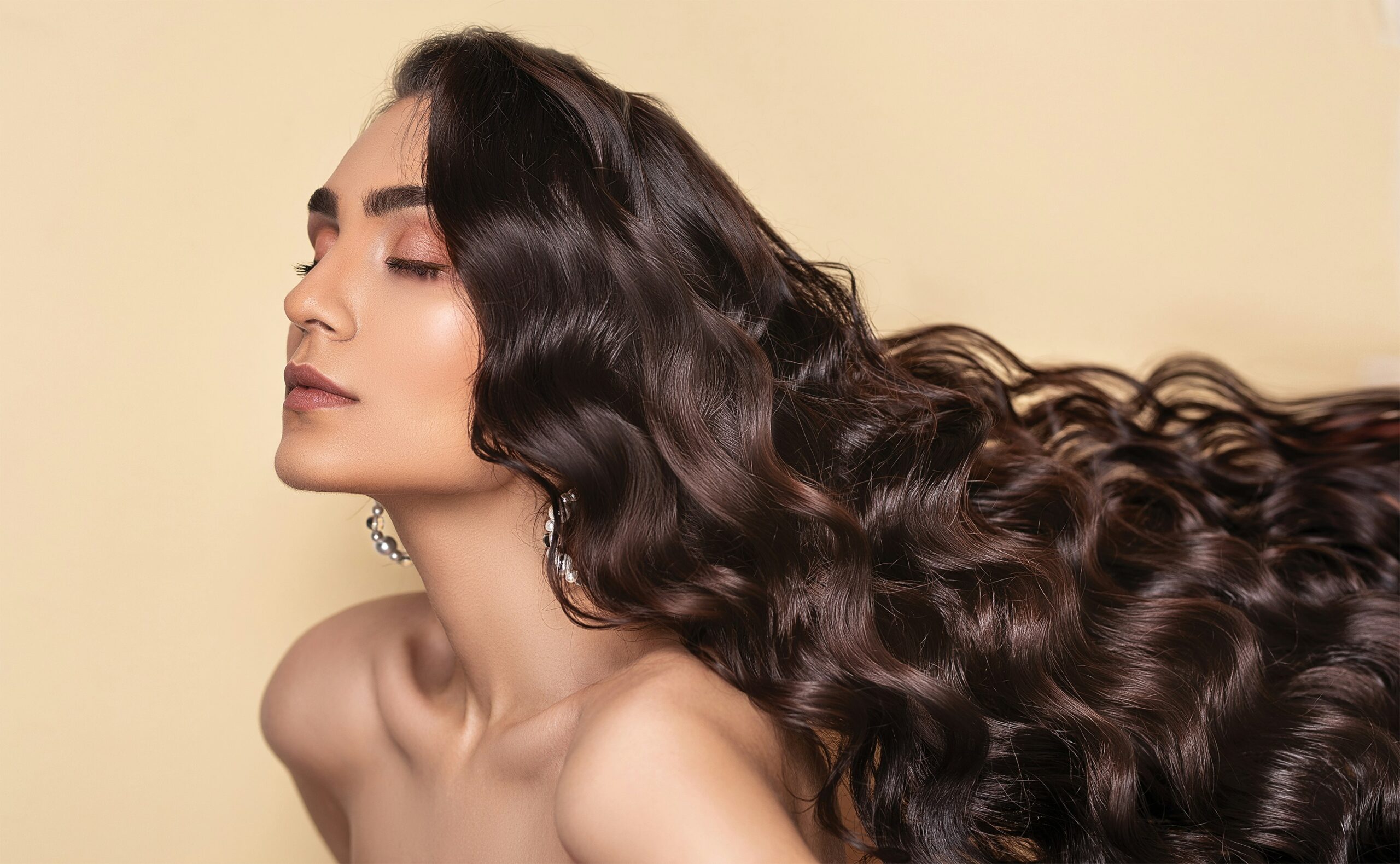 Long wavy hairstyle with rich brunette tones and defined curls