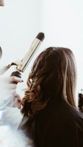 Curling iron styling long hair into soft waves