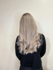 Long straight ash blonde hair, with curled ends, back view