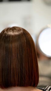 Long straight auburn hair against a dark background