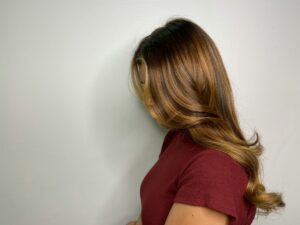 Side profile of glossy brown hair with a deep side part