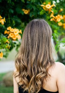 Long wavy balayage hair with a floral background
