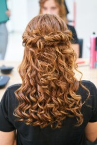 Copper red curly hair styled in a half-up look